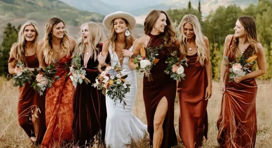 Las damas de honor lucen vestidos en tonos tierra, creando una armonía de colores vibrantes.