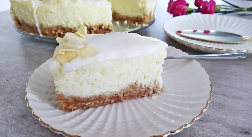 Pyszny sernik z mascarpone na kruchym spodzie, udekorowany płatkami migdałów. Idealny na deser.
