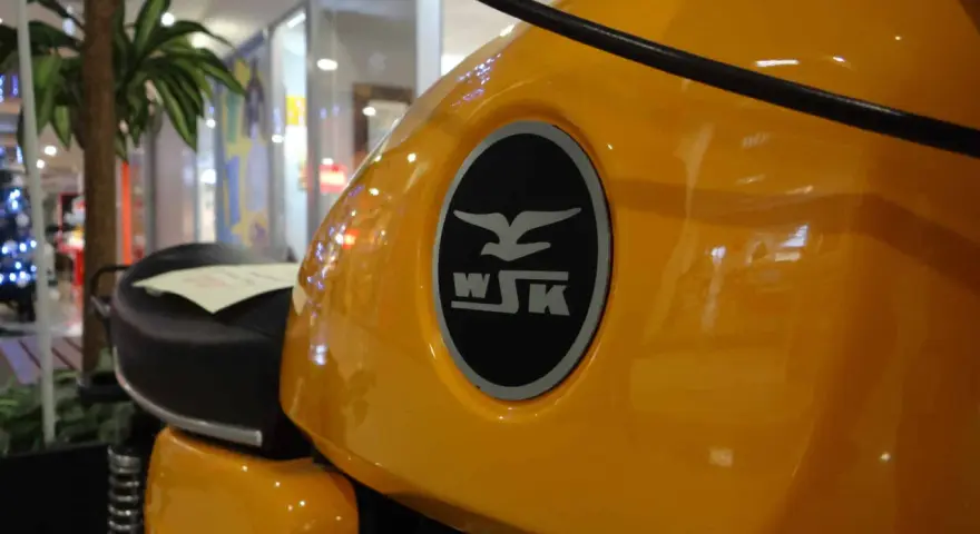 Żółty bak motocykla WSK 125 z charakterystycznym logo. Ile koni kryje się pod tą błyszczącą karoserią?