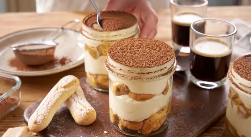 Pyszne tiramisu składniki w słoiczkach, z biszkoptami i kawą.