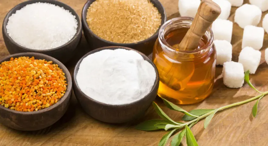 Schalen mit Zucker, Honig, Pollen und Stevia-Blättern – ideale Zutaten für zuckerersatz zum Backen.
