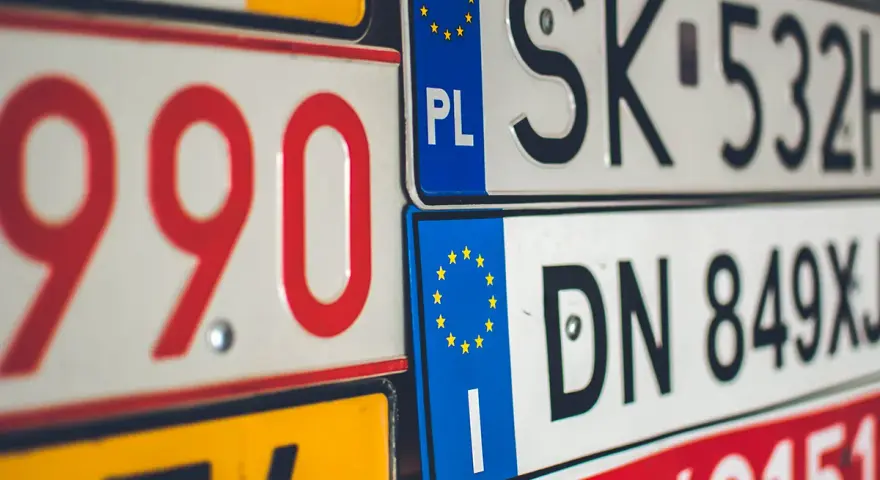 Un'opera d'arte di targhe automobilistiche europee, con numeri rossi e neri su sfondi bianchi e gialli.
