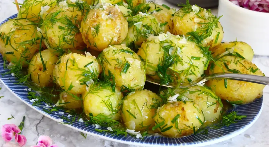 Njut av nykokt färskpotatis med dill och gräslök, en klassiker som visar hur kokar man potatis till perfektion. En svensk flagga vajar stolt.