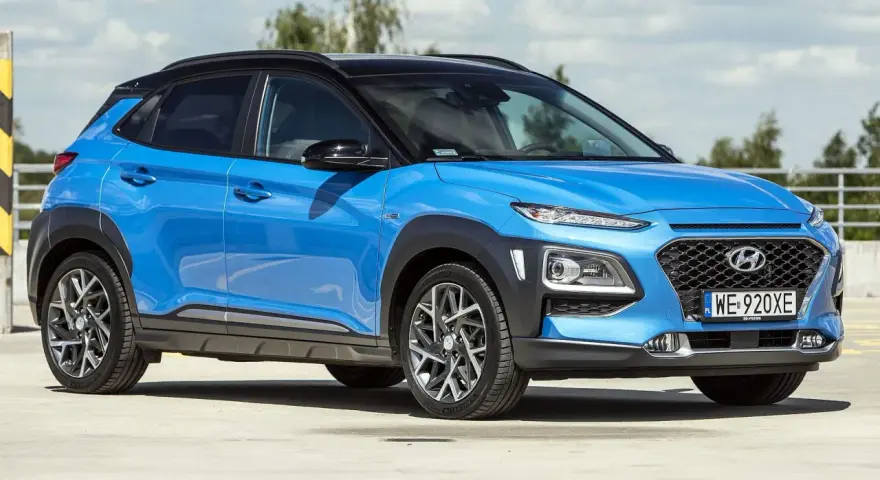 Niebieski Hyundai Kona 2025 z czarnym dachem, zaparkowany na zewnątrz.