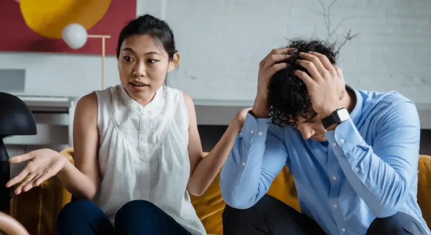 Une femme exprime sa frustration, se sentant incomprise. Son partenaire, accablé, se tient la tête. La communication est difficile dans leur couple.