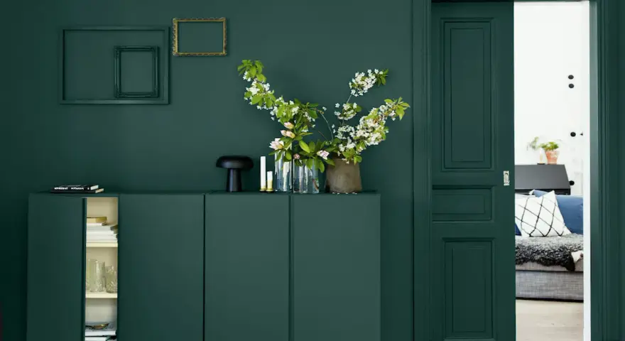 Un buffet vert sapin, des cadres dorés et noirs, des fleurs blanches et roses. Quelle couleur avec le vert sapin ? Le doré ressort magnifiquement.