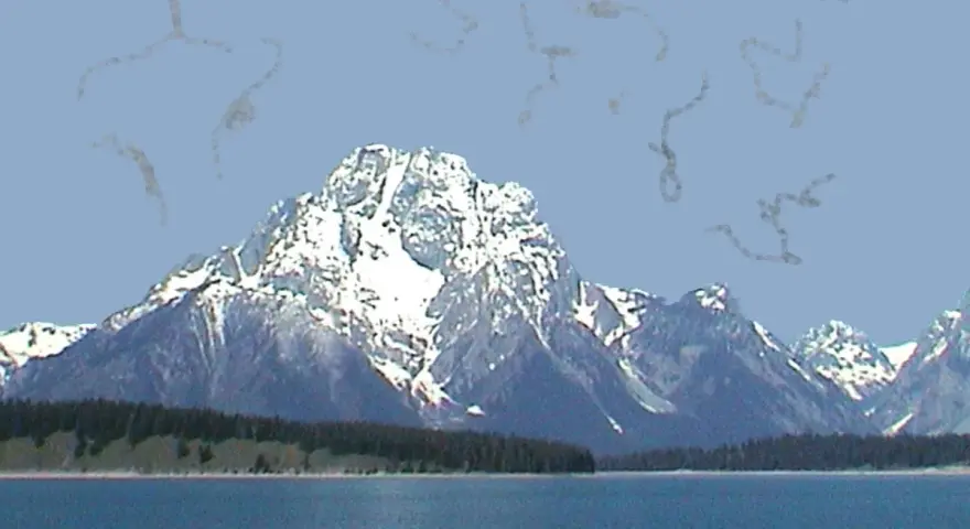 Montagne innevate su uno sfondo azzurro, con strani pallini negli occhi che fluttuano nell'aria.