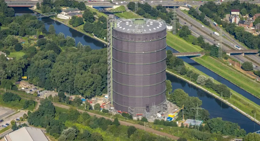 Gasometer Oberhausen aus der Vogelperspektive mit Kanal, Autobahn und Grünflächen.