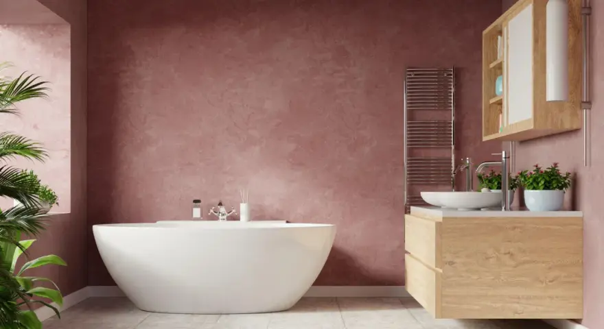 Un elegante bagno con vasca freestanding e mobile lavabo in legno. Le pareti color pesca creano un'atmosfera calda e accogliente, un vero bagno soffitto colorato.