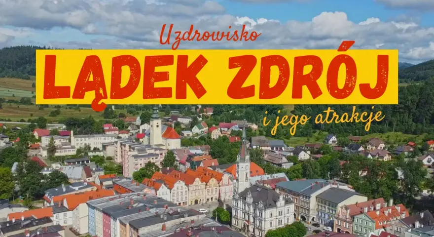 Widok na Lądek Zdrój i jego atrakcje. Miasto z kolorowymi kamienicami, kościołem i zielonymi wzgórzami w tle.