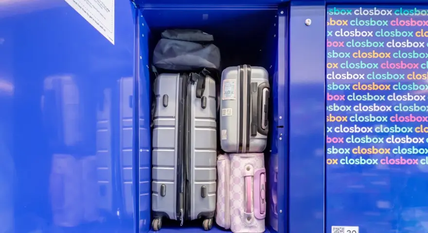 Luggage stored in a blue locker, including suitcases and bags.