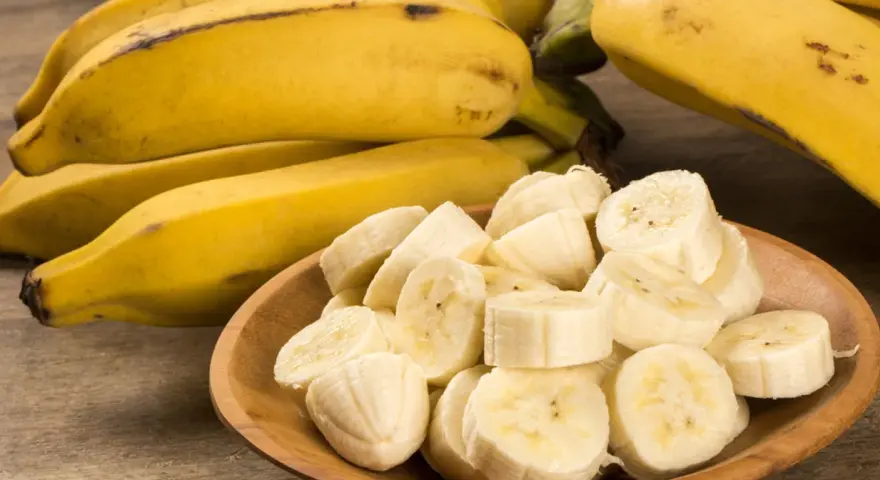 Kawałki banana na drewnianej desce. Banan wartości odżywcze to potas i witaminy.