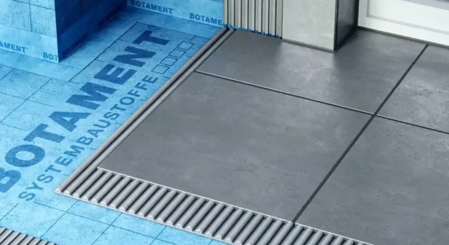 Systemowa hydroizolacja łazienki z niebieską membraną Botament i szarymi płytkami.