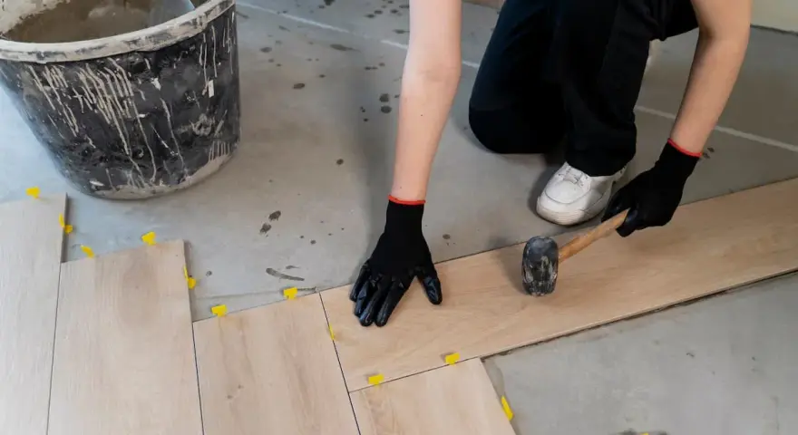 Instalando baldosas de madera, el mejor suelo para garaje particular. Se usa mazo y niveladores.