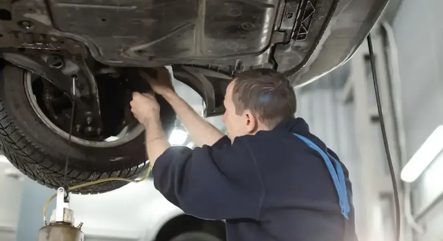 Mechanik wymienia płyn hamulcowy w samochodzie. Dowiedz się, ile kosztuje wymiana płynu hamulcowego.