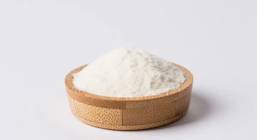 Biały proszek, czyli inulina z cykorii, w drewnianej miseczce.