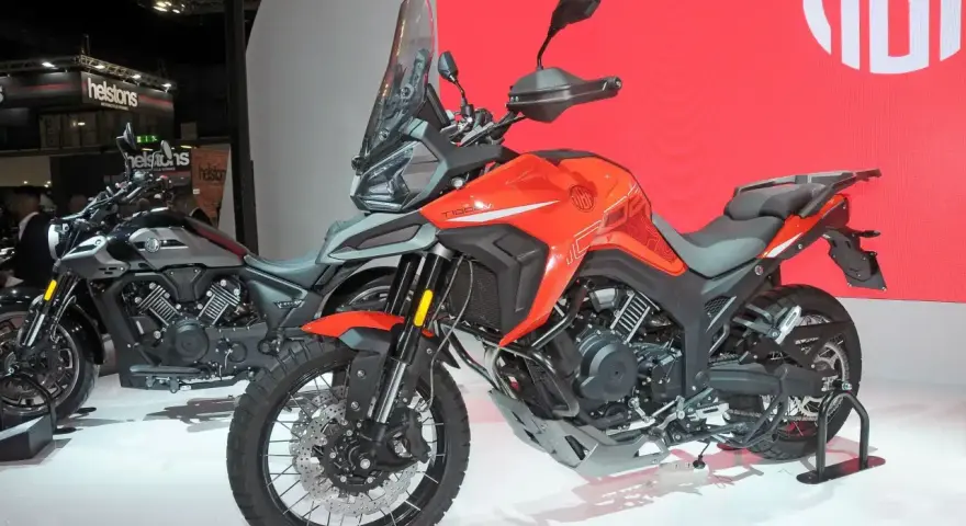 Pomarańczowy motocykl Morbidelli T1002VX na wystawie, gotowy na przygodę. Obok stoi jego szary brat.