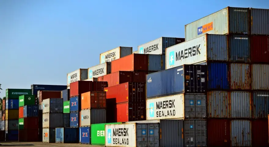 Stos kontenerów w porcie, świadectwo globalnej logistyki Rhenus. Widoczne napisy Maersk, Evergreen, Cronos.