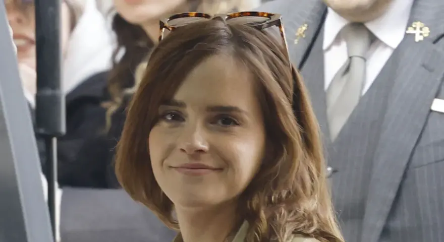Emma Watson, con occhiali da sole sulla testa, sorride. La sua espressione suggerisce una vivacità che alcuni associano all'ADHD.