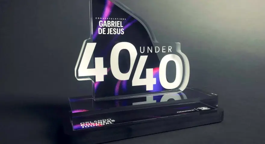 A "40 Under 40" award for Gabriel De Jesus, showcasing how strong is acrylic. The award features a sleek, modern design with vibrant purple and pink accents.
