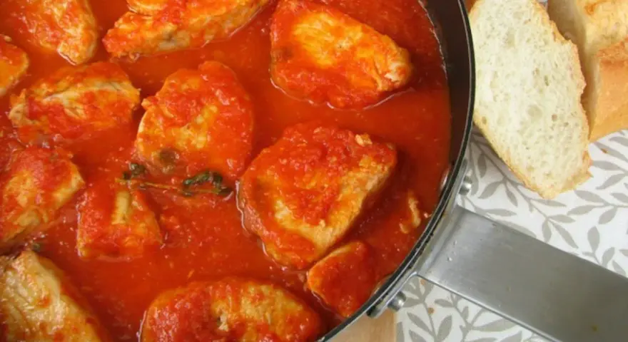 Sabroso pollo en salsa de tomate, como la receta de la abuela. Acompañado de pan crujiente.