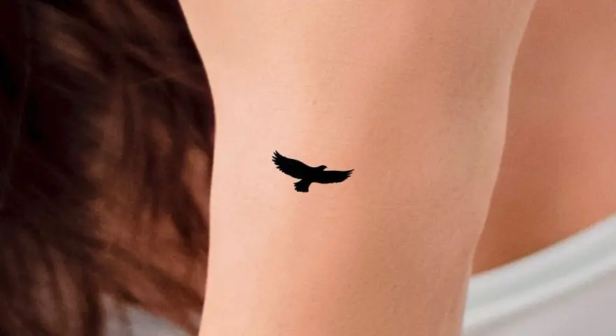 Mały tatuaż orzeł w locie na skórze. Symbol wolności i siły.