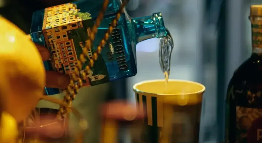 Nalewanie ginu z butelki Portofino do szklanki. Ciekawi Cię, jak smakuje gin?