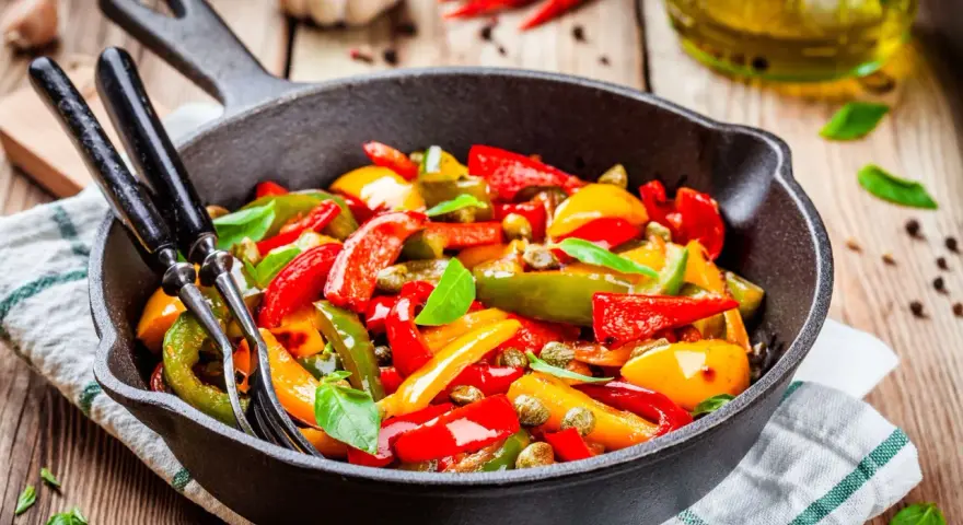 Peperoni in padella, colorati e succosi, pronti per essere gustati. Un contorno semplice e saporito.