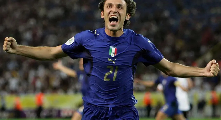 Piłkarz w niebieskiej koszulce reprezentacji Włoch z numerem 21, Andrea Pirlo, świętuje bramkę. Ile lat ma Pirlo?