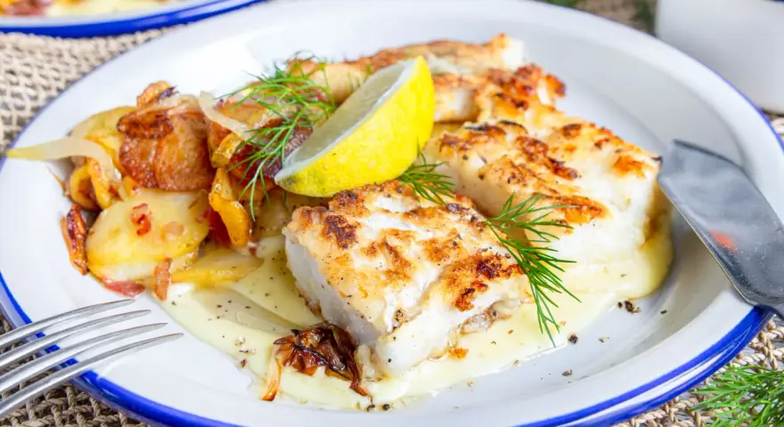 Gebratener Fisch mit Bratkartoffeln und Zwiebeln, garniert mit Dill und Zitrone. So sieht leckerer Pannfisch aus!
