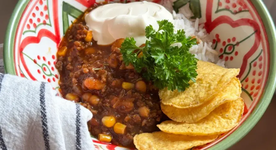 En skål med chili con carne, ris, gräddfil och tortillachips. Perfekt vin till chili con carne!