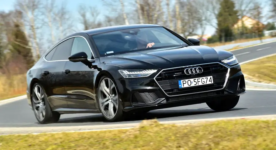 Czarny Audi A7 na drodze. Sprawdź aktualną audi a7 cena i możliwości tego sportowego sedana.