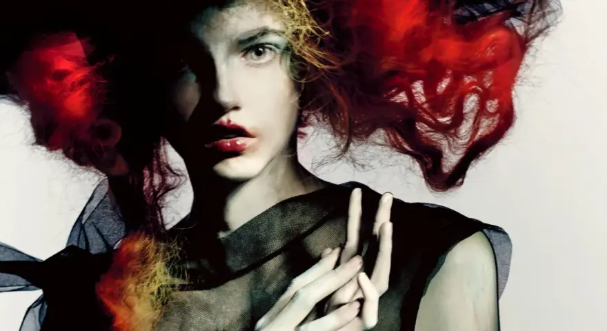Portret kobiety z ognistymi włosami i czarną siatką, w stylu Paolo Roversi.