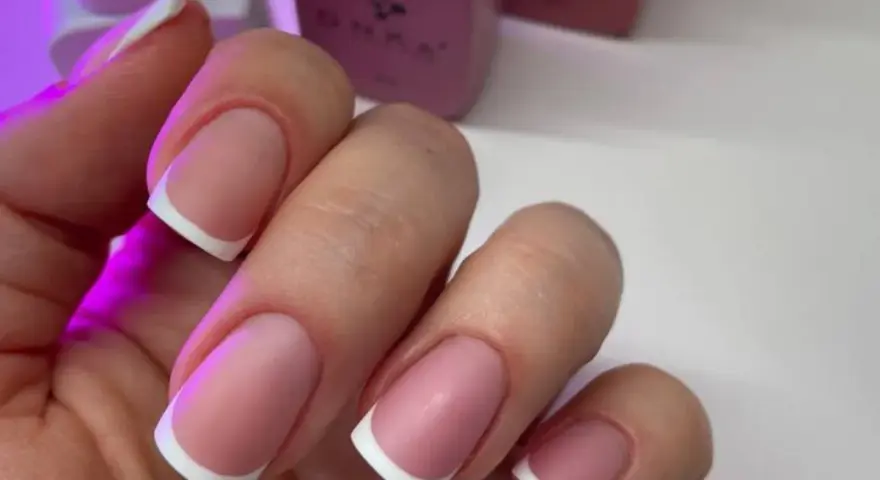 Dłonie z idealnym manicure, klasyczny french na paznokciach.