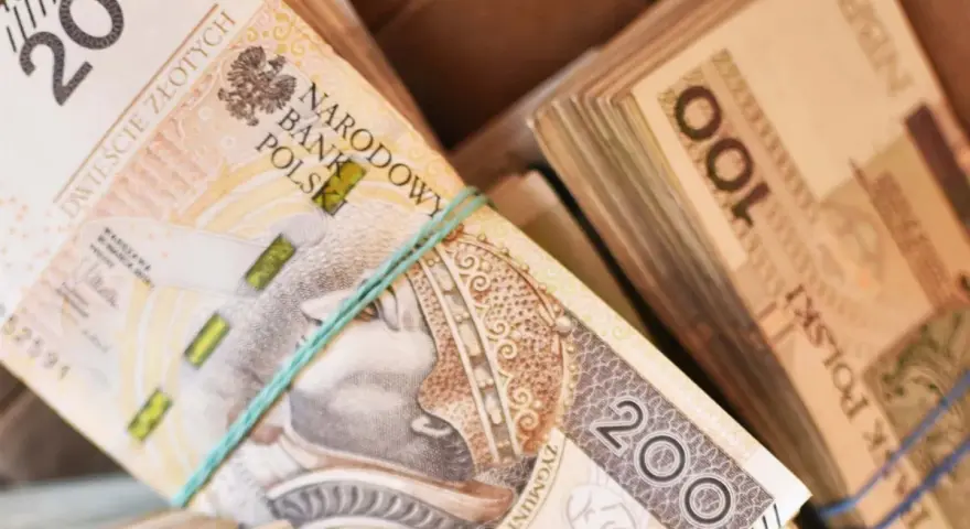 Stosy polskich banknotów 200 zł i 100 zł. Zastanawiasz się, ile zarabia sprzedawca w salonie samochodowym?