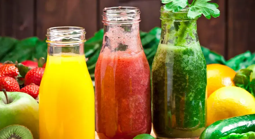 Drei Flaschen mit frisch gepresstem Saft: gelb, rot und grün. Perfekt, um Saft selber machen zu lernen und gesunde Getränke zu genießen.