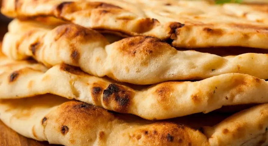 Gestapeltes, frisch gebackenes Naan Brot mit leichten Röststellen. Perfekt zum Dippen!