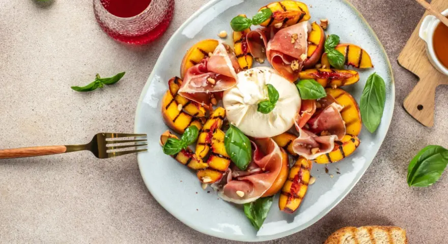 Gegrillte Pfirsiche mit cremigem Burrata, Prosciutto und Basilikum – ein köstlicher Pfirsich Burrata Genuss.