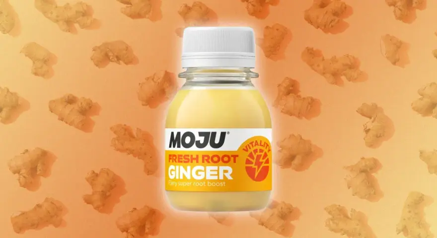 Botella de MOJU con shots de jengibre fresco, rodeada de raíces de jengibre. Un impulso de vitalidad.