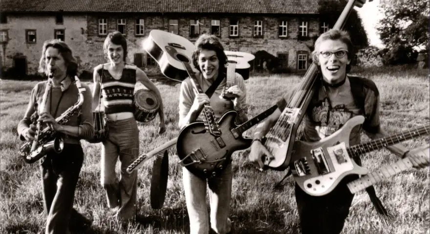Vier Musiker mit Gitarren und Saxophon, ein Schlagzeuger. Eine Szene, die an deutsche Bands der 70er erinnert, voller Energie und Musik.