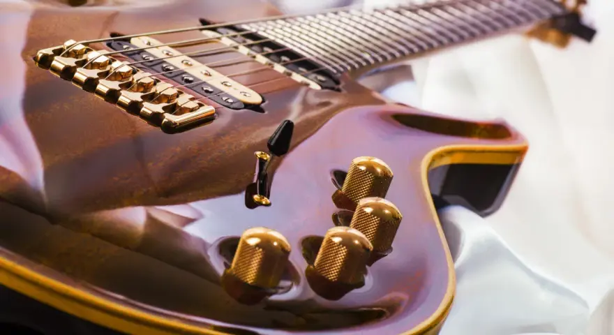 Glänzende E-Gitarre mit goldenen Details, bereit, um das Gitarre lernen zu beginnen.