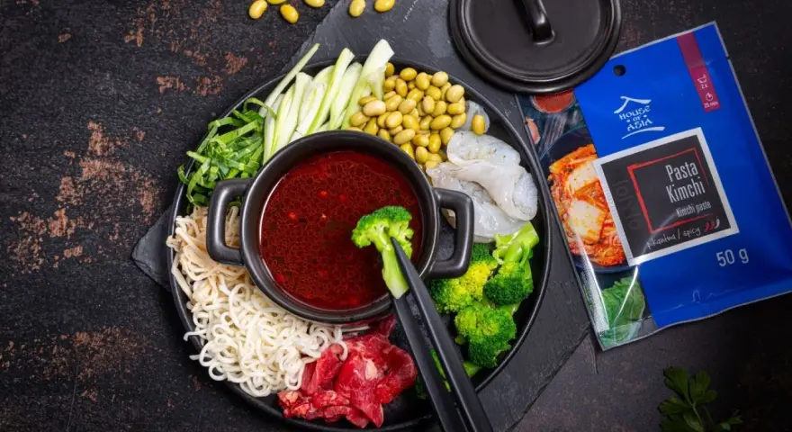Składniki do hot pot z pastą kimchi: makaron, krewetki, wołowina, brokuły, fasolka edamame, ogórek i zielenina.