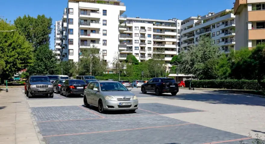 Nowoczesne osiedle w Warszawie, parking z samochodami. Zastanawiasz się, ile kosztuje kawalerka w Warszawie?