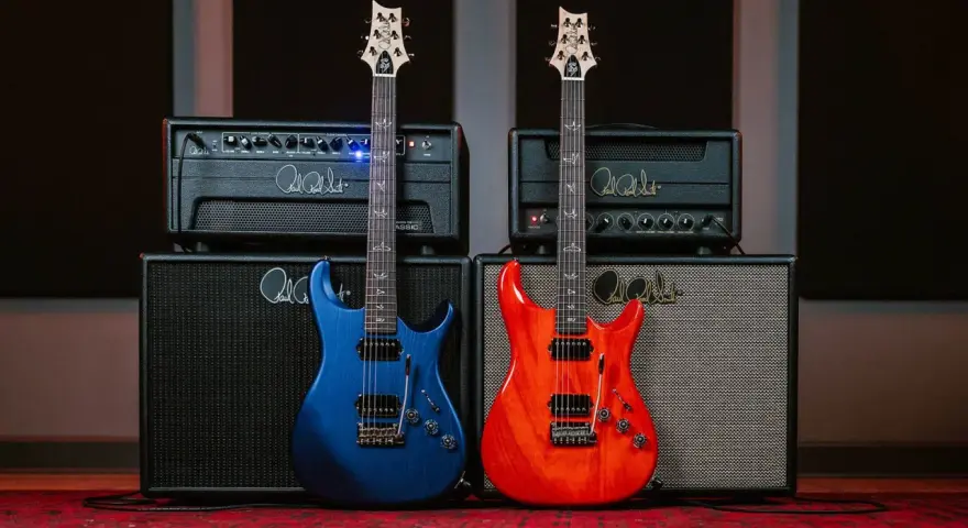 Dwie gitary, niebieska i pomarańczowa, stoją przed wzmacniaczami. Idealne guitar samples dla każdego muzyka.