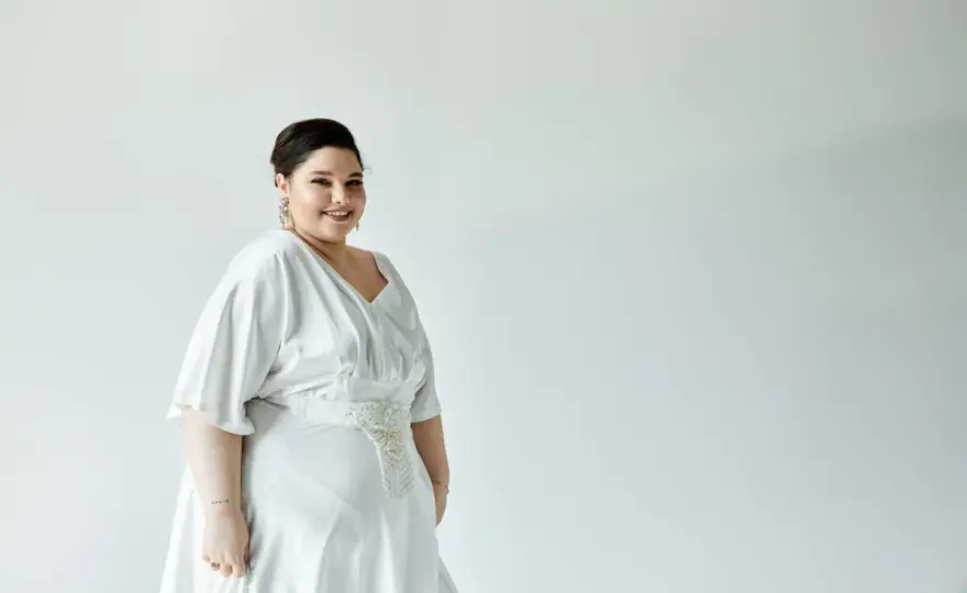 Sukienki na wesele maskujące brzuch: Fasony, które wyszczuplają