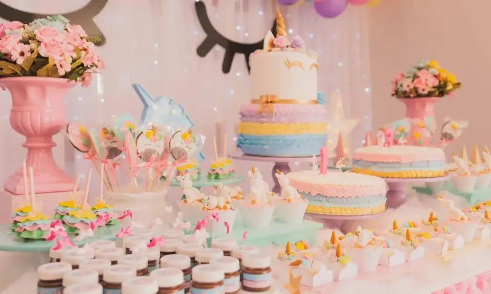 Mesa de dulces temática de unicornios con pasteles, galletas, cupcakes y más postres para una fiesta mágica.