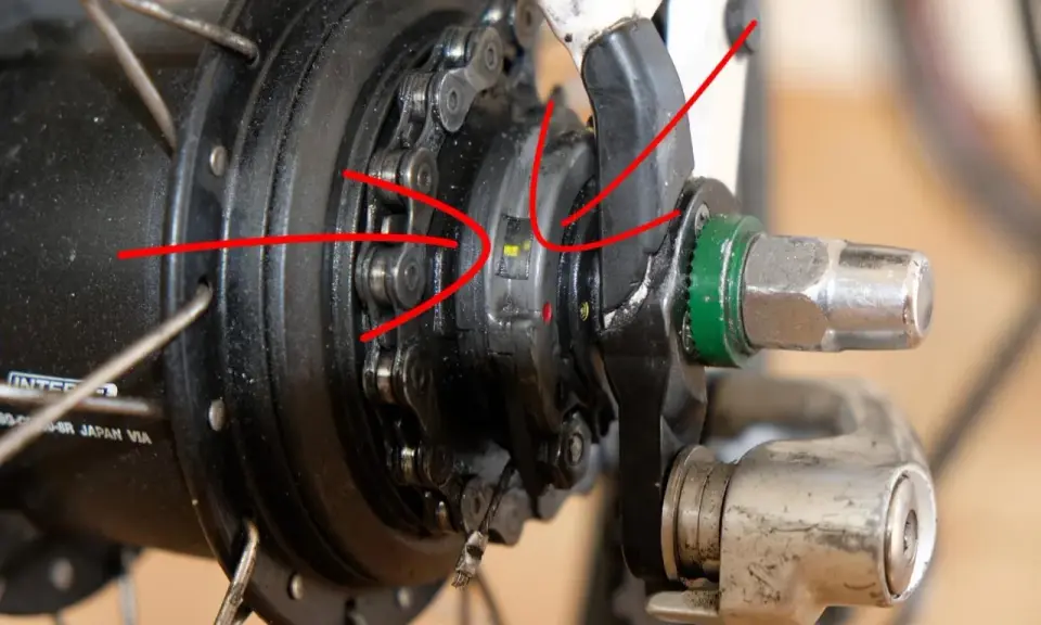 Rote Pfeile zeigen auf die Markierungen zum shimano nexus 8 einstellen. Nahaufnahme einer Nabenschaltung.