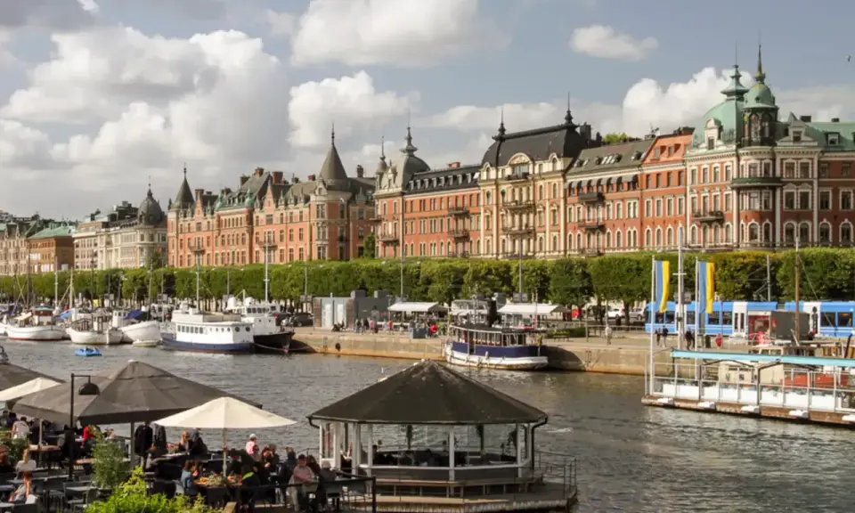 En dag i Stockholm vid vattnet med vackra byggnader, båtar och uteserveringar.