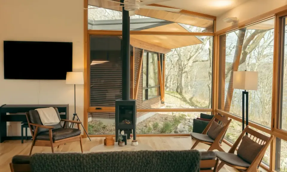 Salon moderne avec poêle à granulés 8 kw. Combien de m2 peut-il chauffer ? Fenêtres panoramiques, mobilier design, vue sur la nature.