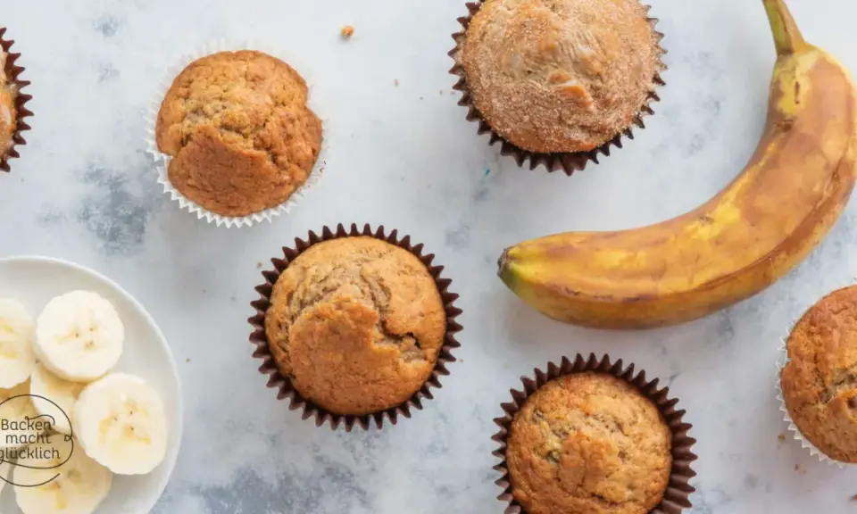 Saftige bananen muffins, ein reifer Banane und Bananenscheiben auf einem Teller. Perfekt für den Kaffeetisch.
